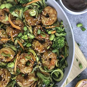 Simple Teriyaki Shrimp over Zucchini Noodles - this recipe is made with a homemade teriyaki sauce and served over zucchini noodles. Making for an easy, healthy and extremely delicious dinner option that can be on your table in 30 minutes! #shrimp #teriyaki #easy #healthy #shrimpteriyaki #zoodles #zucchininoodles | www.withpeanutbutterontop.com