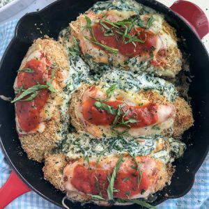 Spinach and Cream Cheese Stuffed Chicken Parmesan - this baked chicken recipe is the bomb when it comes to flavor! The chicken is stuffed with spinach and cream cheese and coated with a crispy breadcrumb coating. Tender and juicy on the inside, crispy on the outside, and flavorful throughout. Best part? All you need is one pan. #chickenparmesan #chicken #onepan #dinner #stuffedchicken | www.withpeanutbutterontop.com