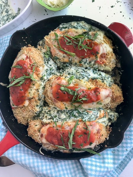 Spinach and Cream Cheese Stuffed Chicken Parmesan - this baked chicken recipe is the bomb when it comes to flavor! The chicken is stuffed with spinach and cream cheese and coated with a crispy breadcrumb coating. Tender and juicy on the inside, crispy on the outside, and flavorful throughout. Best part? All you need is one pan. #chickenparmesan #chicken #onepan #dinner #stuffedchicken | www.withpeanutbutterontop.com