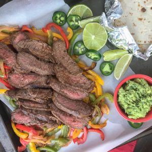 The Best and Easiest Garlic Lime Steak Fajitas -  these steak fajitas are easier to make than you think and absolutely delicious! Tender marinated flat iron steak served with sautéed bell peppers, onions, and a creamy Cilantro Lime Avocado Mash. #steak #dinner #easy #steakfajitas #fajitas #mexican #onepan | www.withpeanutbutterontop.com