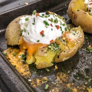 Crispy Loaded Garlic Smashed Potatoes -  potatoes baked with garlic, parsley, onion powder, parmesan cheese and butter. Better than the traditional baked potato, easy to make, and truly the best way to serve potatoes if they are not in fry form! #potatoes #easy #sidedish #dinner | https://withpeanutbutterontop.com