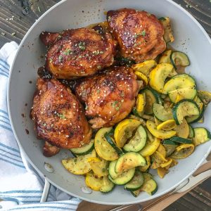 This One-Pan Honey Garlic Chicken Thighs and Squash recipe is the bee's knees! The chicken thighs are cooked in an incredibly delicious honey garlic sauce glaze and is easy to make. Bonus: this entire recipe is cooked using only one pan, making cleanup a breeze! #chickenthighs #honeygarlic #onepan #dinner #chicken | https://withpeanutbutterontop.com