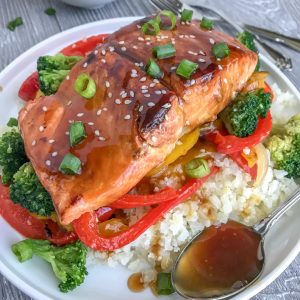 Honey Teriyaki Salmon with Cauliflower Rice - a deliciously sticky, sweet and savory dish that can be on your table in under 30 minutes. Skip the high-calorie, high-carb takeout and try this healthier, low-carb rendition! #healthy #takeout #teriyaki #salmon #cauliflowerrice | https://withpeanutbutterontop.com