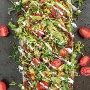 Loaded Skinny Taco Flatbread Pizza - a healthier, lower-carb version of our favorite pizza! Loaded with toppings, easy and quick to make! #pizza #tacos #tacopizza #tacotuesday | https://withpeanutbutterontop.com