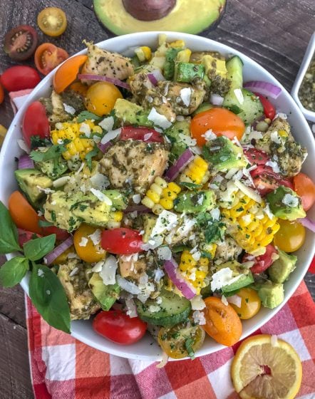 This healthy, super simple to make, and delicious Lemon Pesto Chicken Avocado Salad recipe is loaded with avocado, cherry tomatoes, red onions, corn, and the most delicious lemon pesto chicken. #healthy #pestochicken #salad | https://withpeanutbutterontop.com