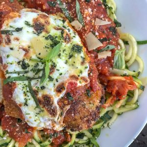 Crispy Baked Chicken Parmesan Zucchini Bowls - incredibly delicious chicken that is super tender on the inside, yet crispy on the outside. Served over cooked zucchini noodles to make for a lower-carb, light and healthy meal. #chickenparmesan #zoodles #healthy #lowcarb | https://withpeanutbutterontop.com