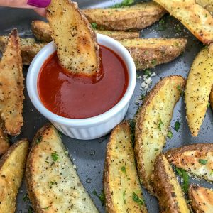 Crispy Baked Garlic Parmesan Potato Wedges - the best potato wedges you will ever try! Crispy on the outside, flaky on the inside, and flavorful throughout thanks to the garlic, parmesan seasoning! No tricks or extra work! #potatowedges #apppetizers #crispyfries | https://withpeanutbutterontop.com