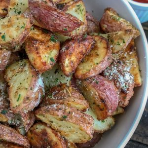 Super Crispy Garlic Parmesan Potato Bites - this is the perfect side dish to your dinner tonight! Easy to make, ready in 30-35 minutes, and sure to be a hit at your table! Crispy on the outside and light and fluffy on the inside like potatoes should be! #sidedish #crispypotatoes #ovenroastedpotatoes #baked | https://withpeanutbutterontop.com