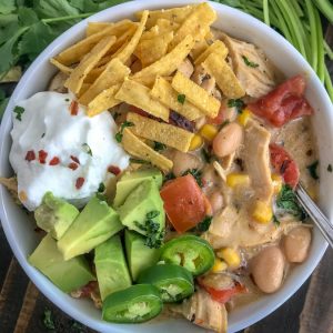 Easy One Pot White Chicken Chili - lightened up! This chili is filled with chicken breast, beans, corn, tomatoes, and that great Tex Mex flavor! Simple to make and all done in one pot! #easy #easydinners #healthy #soups | https://withpeanutbutterontop.com