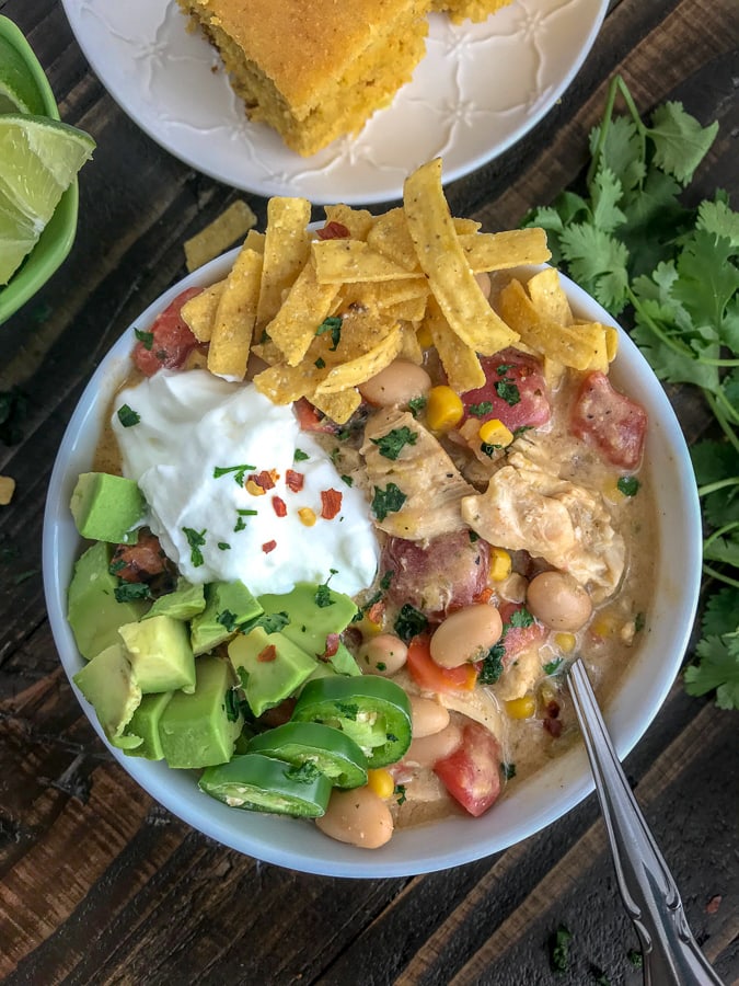 Easy One Pot White Chicken Chili - lightened up! This chili is filled with chicken breast, beans, corn, tomatoes, and that great Tex Mex flavor! Simple to make and all done in one pot! #easy #easydinners #healthy #soups | https://withpeanutbutterontop.com