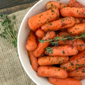 Maple Roasted Carrots - super simple and delicious side dish made with maple syrup, olive oil, and herbs. 5 minutes to prep and a great addition to any meal! #roastedcarrots #sidedish #easyrecipes #thanksgiving | https://withpeanutbutterontop.com