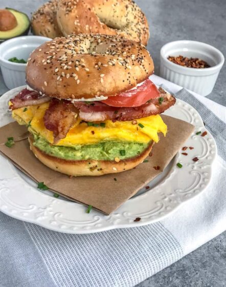 Bacon Egg and Avocado Breakfast Bagel - an easy, filling and flavorful breakfast! Made with fluffy, scrambled eggs, sliced tomato, bacon, cream cheese, and a delicious garlic avocado mash - all sandwiched between an everything bagel. Breakfast has been perfected! #breakfast #bagel #breakfastbagel