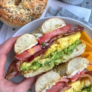 Bacon Egg and Avocado Breakfast Bagel - an easy, filling and flavorful breakfast! Made with fluffy, scrambled eggs, sliced tomato, bacon, cream cheese, and a delicious garlic avocado mash - all sandwiched between an everything bagel. Breakfast has been perfected! #breakfast #bagel #breakfastbagel