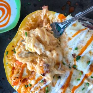 Creamy Buffalo Chicken Stuffed Spaghetti Squash - if you're a buffalo chicken and pasta fan, but are trying to cut back on the carbs - you are going to love this recipe! Spaghetti squash stuffed with shredded chicken, cheeses, sautéed peppers and onions, and a creamy buffalo sauce. Guaranteed to become a repeat meal! #buffalochicken #stuffedspaghettisquash #lowcarb | https://withpeanutbutterontop.com