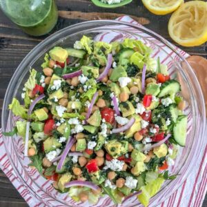 This beautiful, delicious Mediterranean Salad is an easy to throw together meal filled with crunchy cucumber, red bell peppers, onions, and chickpeas all tossed in an easy homemade vinaigrette. Sure to become a favorite #MeatlessMonday meal option! #chickpeas #salad #mediterraneansalad | https://withpeanutbutterontop.com