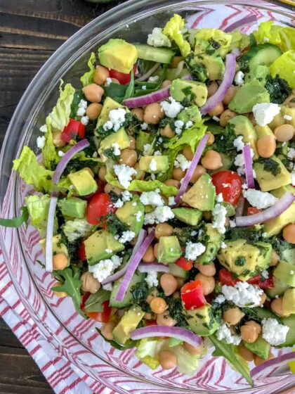 This beautiful, delicious Mediterranean Salad is an easy to throw together meal filled with crunchy cucumber, red bell peppers, onions, and chickpeas all tossed in an easy homemade vinaigrette. Sure to become a favorite #MeatlessMonday meal option! #chickpeas #salad #mediterraneansalad | https://withpeanutbutterontop.com