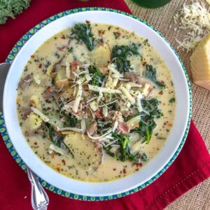 Make one of Olive Garden's most popular soups, but at home and on a healthier, lighter note! This soup is rich, creamy and full of flavor. You won't be able to tell that it's not from Olive Garden! Filled with tender potatoes, bacon, turkey sausage and kale, this soup is perfect for these cold wintery days! #olivegarden #zuppatoscana #soup #onepot | https://withpeanutbutterontop.com