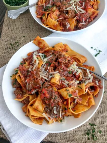 Fall apart tender, shredded beef in a rich, fire-roasted tomato sauce that is tossed with pappardelle pasta and topped with freshly grated parmesan cheese. The ultimate comfort dish made easily in your Instant Pot! #ragu #pappardelle #instantpot #comfortfood #easyrecipes | https://withpeanutbutterontop.com