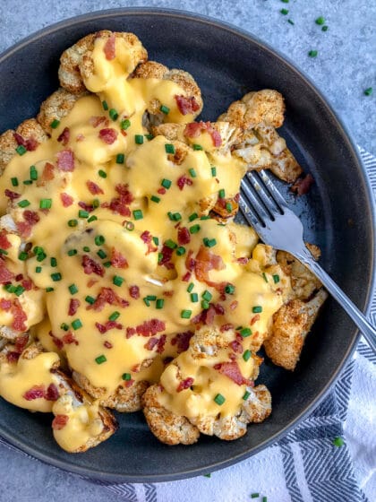 Fork tender cauliflower seasoned and roasted to perfection in a creamy cheddar cheese sauce. A lighter, healthier version of macaroni and cheese that is full of so much flavor - you'll forget about the pasta! #roastedcauliflower #cauliflower #cauliflowerandcheese #appetizer | https://withpeanutbutterontop.com