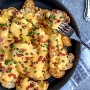 Fork tender cauliflower seasoned and roasted to perfection in a creamy cheddar cheese sauce. A lighter, healthier version of macaroni and cheese that is full of so much flavor - you'll forget about the pasta! #roastedcauliflower #cauliflower #cauliflowerandcheese #appetizer | https://withpeanutbutterontop.com