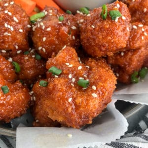 Cauliflower florets battered and baked until super crispy and then tossed in the an incredible sweet and spicy sauce. Sticky, crispy and so easy to make, you’ll be throwing your takeout menus away! #firecracker #firecrackercauliflower #cauliflower #takeout | https://withpeanutbutterontop.com