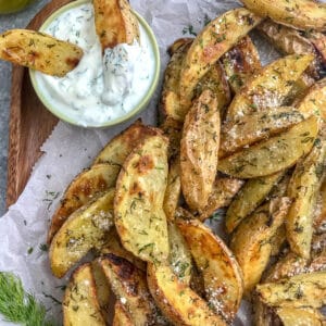 Calling all dill pickle lovers! These potato wedges are crispy on the outside, while being tender and flaky on the inside, with a hint of delicious dill pickle flavoring! The perfect appetizer or side dish to grilled chicken or burgers! #dillpickle #potatowedges #appetizer | https://withpeanutbutterontop.com
