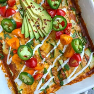 Creamy, shredded chicken stuffed into zucchini "rolls" and then baked in enchilada sauce and cheddar and monetary jack cheese. Very easy to make, low-carb, keto-friendly, and full of amazing flavors! #chickenenchiladas #lowcarb #keto #enchiladas | https://withpeanutbutterontop.com