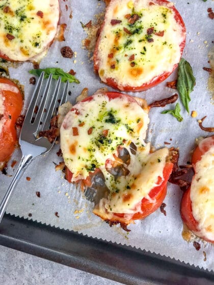 Easy sheet pan appetizer for tomato slices baked with mozzarella and parmesan cheeses.