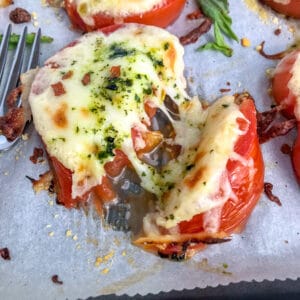 Easy sheet pan appetizer for tomato slices baked with mozzarella and parmesan cheeses.