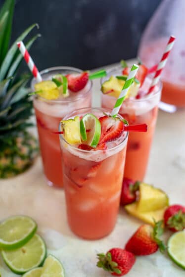 Glasses filled with Sparkling Strawberry Pineapple Limeade.