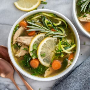 Two bowls filled with Lemon Chicken Zoodle Soup.