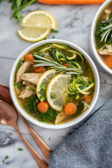 Two bowls filled with Lemon Chicken Zoodle Soup.