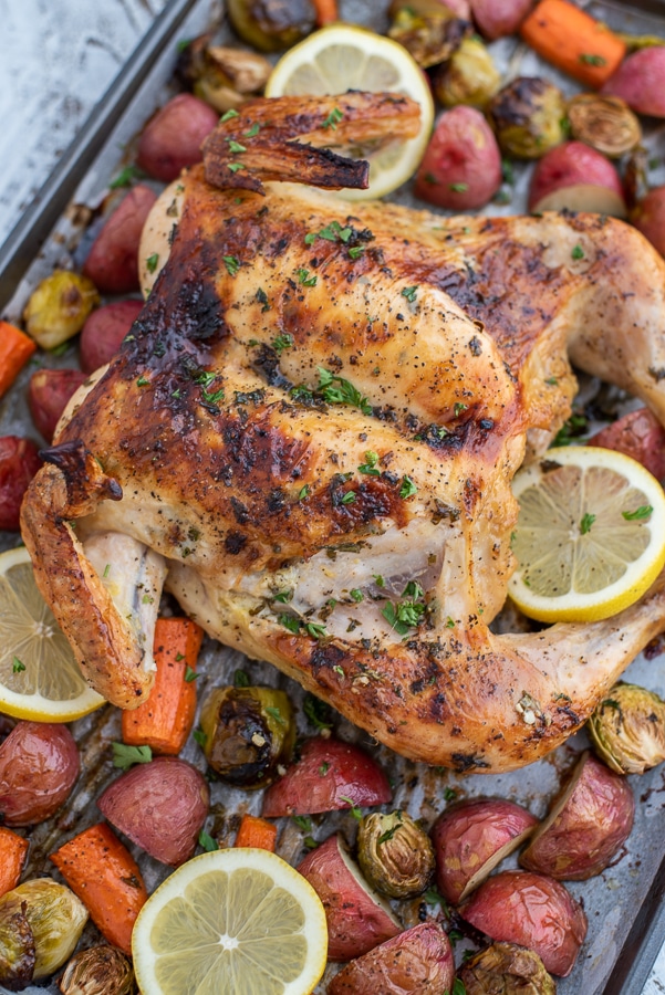 Sheet pan of a butterflied chicken breast with mixed vegetables.