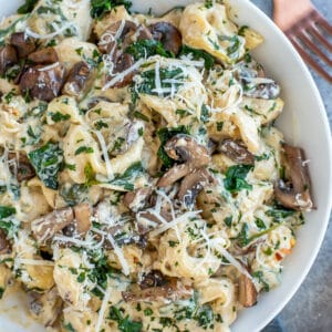 Pan filled with creamy pasta, mushrooms, and spinach.