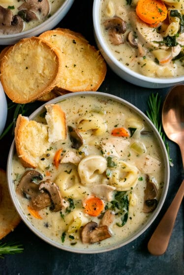 Bowls filled with creamy soup with mushrooms, tortellini and chicken. Served with toasted bread.