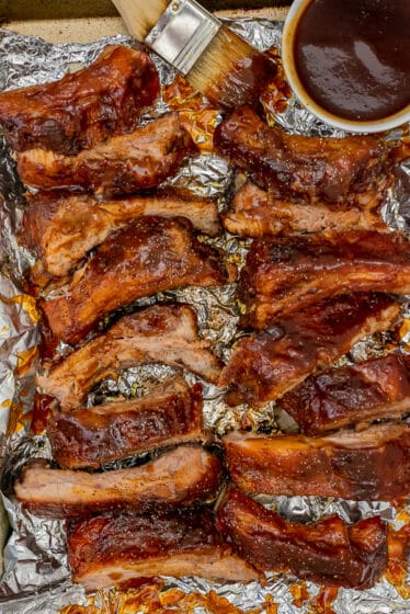 Sheet pan with bbq ribs and extra sauce.