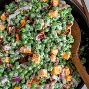 Black bowl filled with a creamy bacon pea salad.