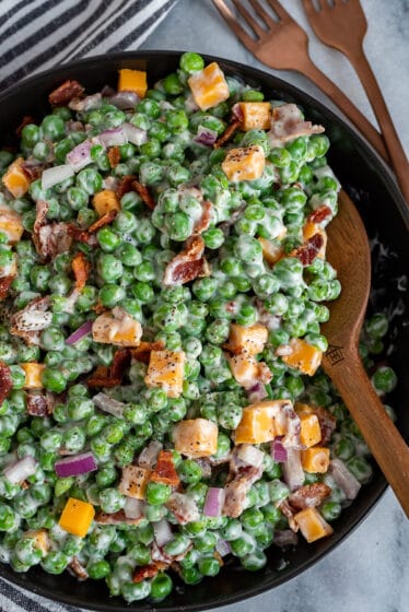 Black bowl filled with a creamy bacon pea salad.