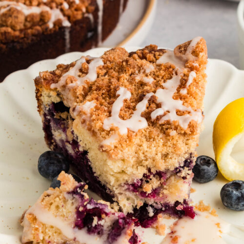 Slice of lemon blueberry coffee cake showing soft crumb and blueberries.